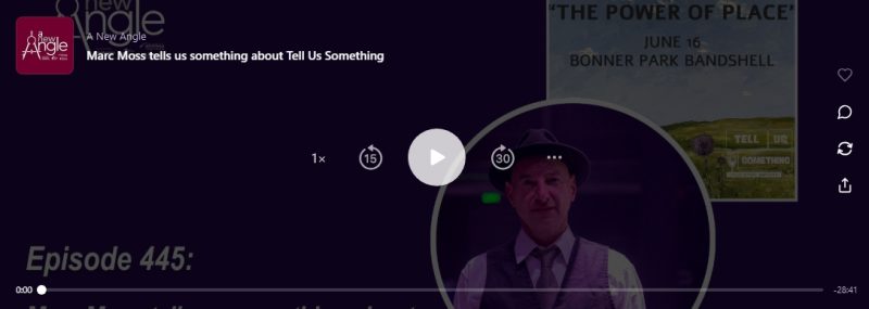 The image shows a dark-themed digital audio player interface for a podcast episode web page. Text Details Podcast Title: In the upper left corner, it notes the show name, A New Angle. Episode Title: The main text reads, "Marc Moss tells us something about Tell Us Something". Episode Number: In the lower left corner, large grey text partially cut off reads "Episode 445:". Imagery & Graphics Center Portrait: Inside a large circular frame in the lower center, there is a portrait of a man (Marc Moss) wearing a dark fedora hat, a white collared shirt, a tie, and a dark vest. The lighting on his face has a moody red or purple hue. Event Poster (Top Right): In the upper right background, a square flyer is partially visible. It features an oil painting landscape with the words "THE POWER OF PLACE", "JUNE 16", and "BONNER PARK BANDSHELL", alongside a small "Tell Us Something" logo. Podcast Logo (Top Left): A small burgundy square icon features the stylized "a new angle" logo featuring a mathematical compass graphic. Player Controls The bottom features a timeline progress bar sitting at 0:00 on the left and indicating a total remaining time of -28:41 on the far right. Standard player icons sit in the center, including a prominent circular white Play button, a "1×" speed modifier, a "skip back 15 seconds" loop, a "skip forward 30 seconds" loop, and a three-dot menu icon (...). Four stacked social icons appear on the far right edge: a heart (like), a speech bubble (comment), a circular refresh arrow (repost/share), and an upload arrow (export/share link).